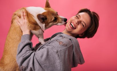 Una ragazza felice gioca con il proprio cane.